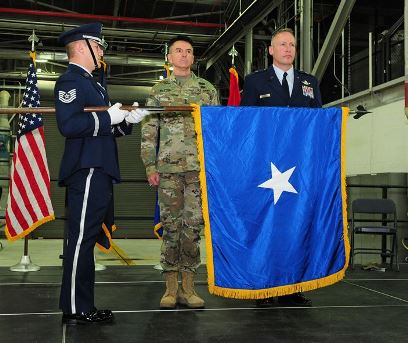 A Brig. Gen. is presented with a flag during his promotion ceremony to the rank of brigadier general